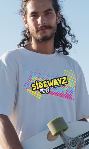 A person with long curly hair holds a skateboard and wears a white t-shirt with a colorful SIDEWAYZ graphic and the words Skater Dude beneath it. The background is bright and clear.